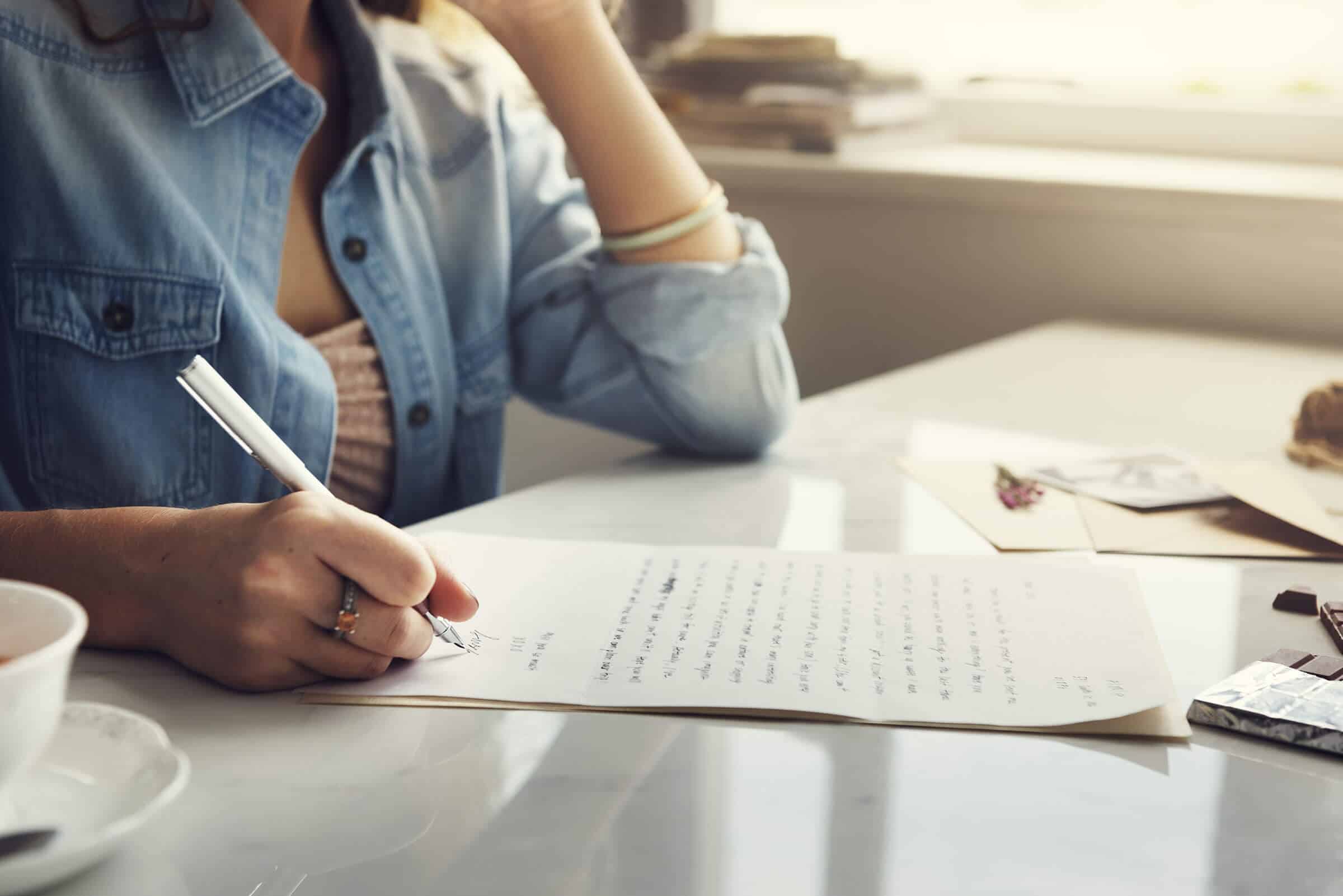 Decorative header featuring an unidentifiable woman sitting at a table hand writing a letter.