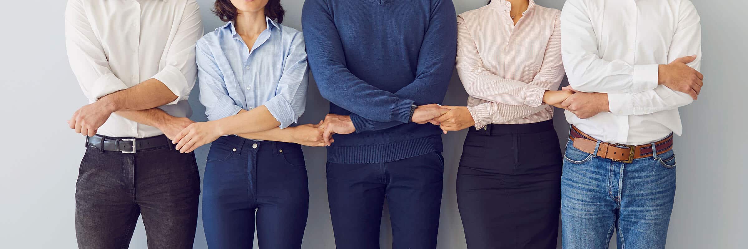 Decorative header photo of a group of men and women holding-hands united in community